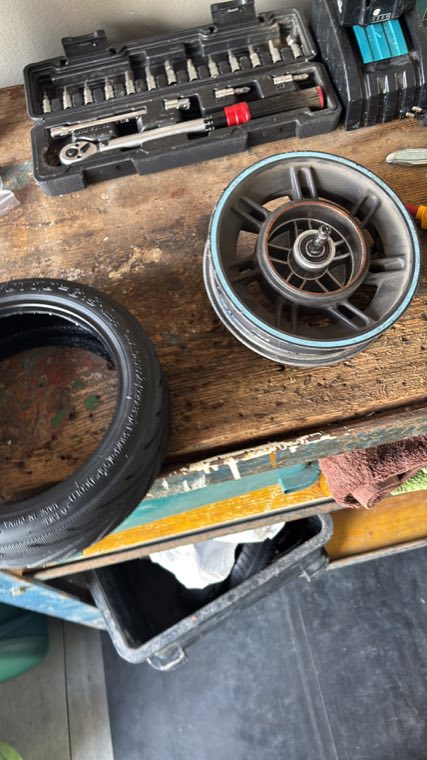 Ausgebautes E-Scooter-Rad neben dem Werkzeug auf der Werkbank